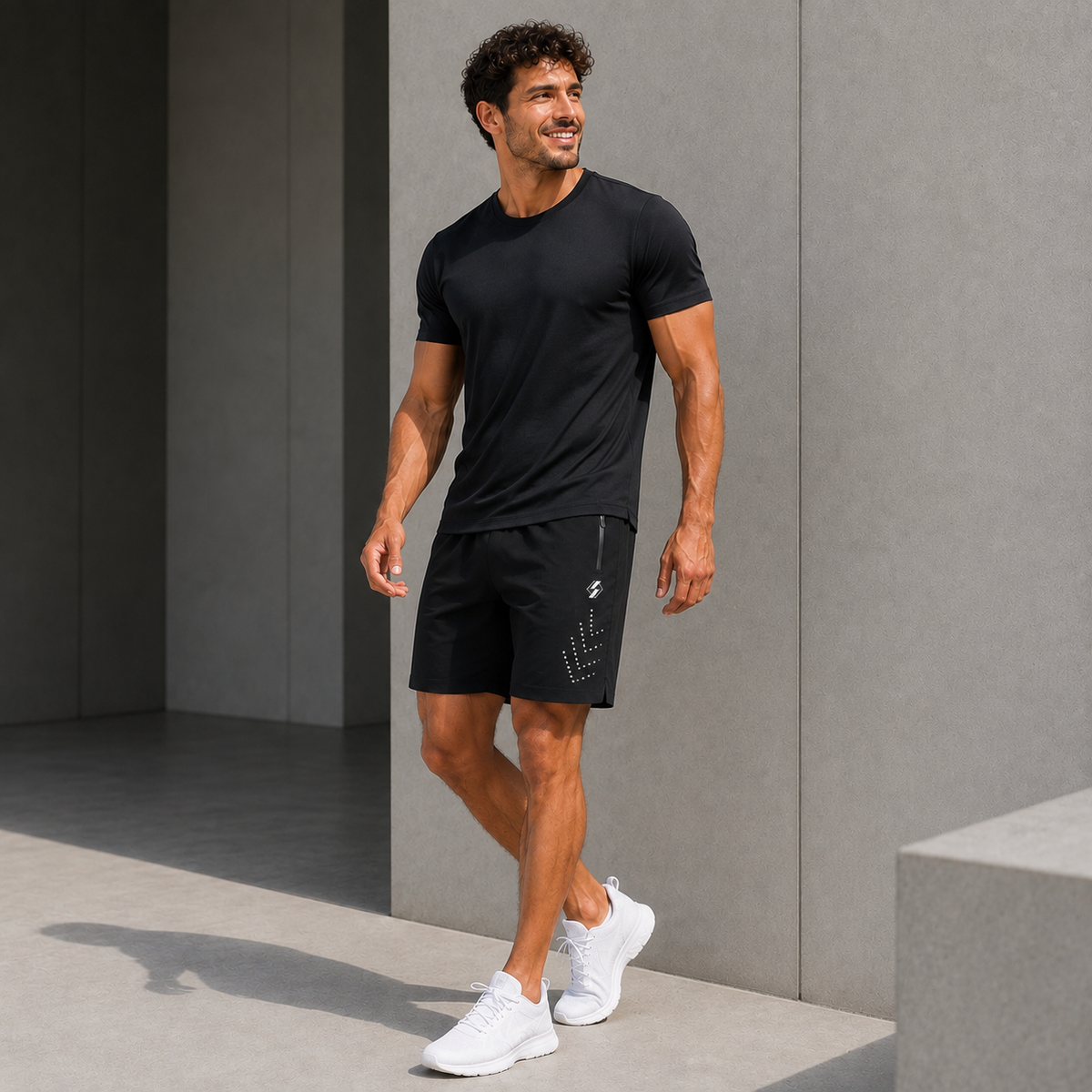 Homme portant le short de padel noir avec détails réfléchissants et t-shirt noir, photo lifestyle en extérieur