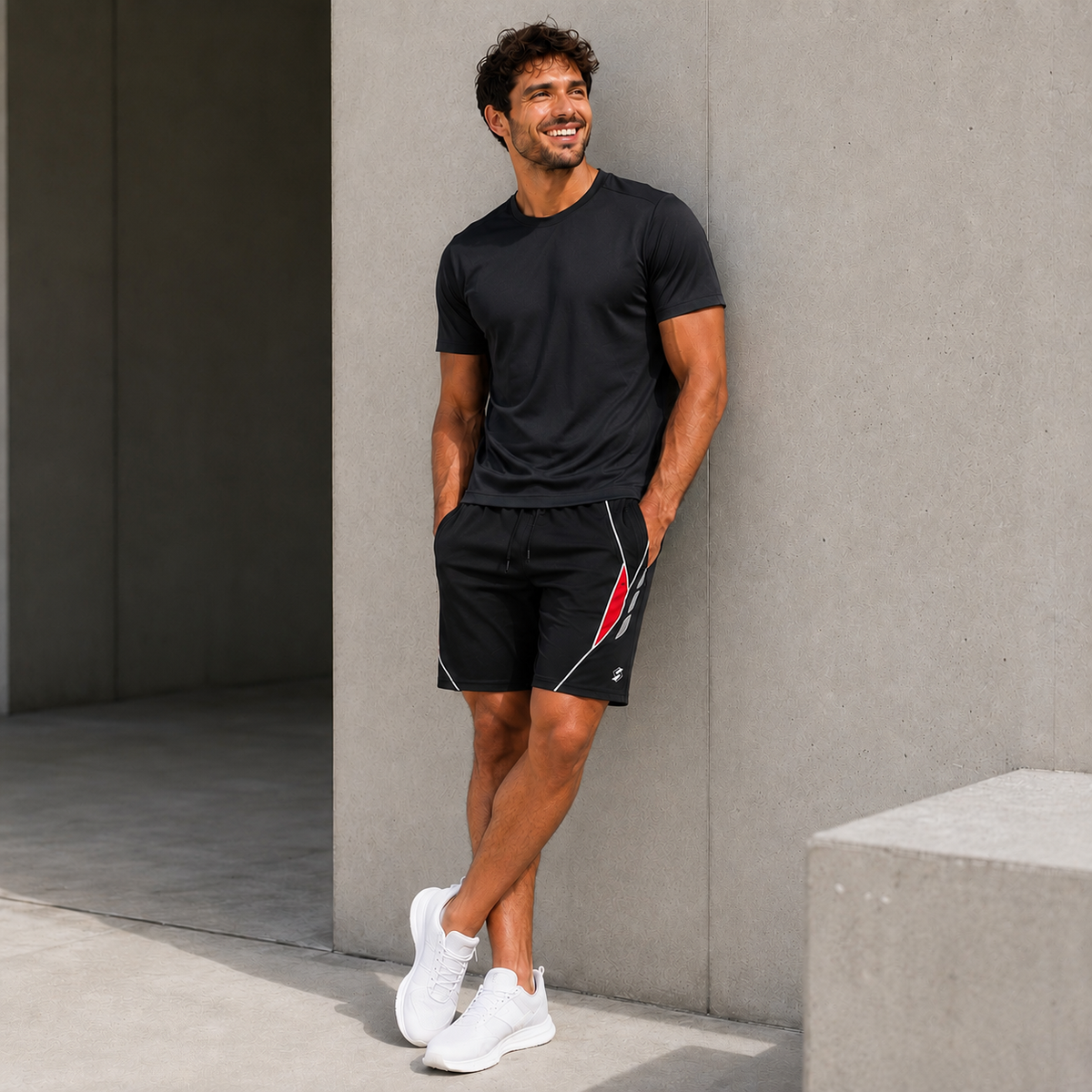 Homme portant le short de padel noir avec accent rouge et t-shirt noir, photo lifestyle en extérieur