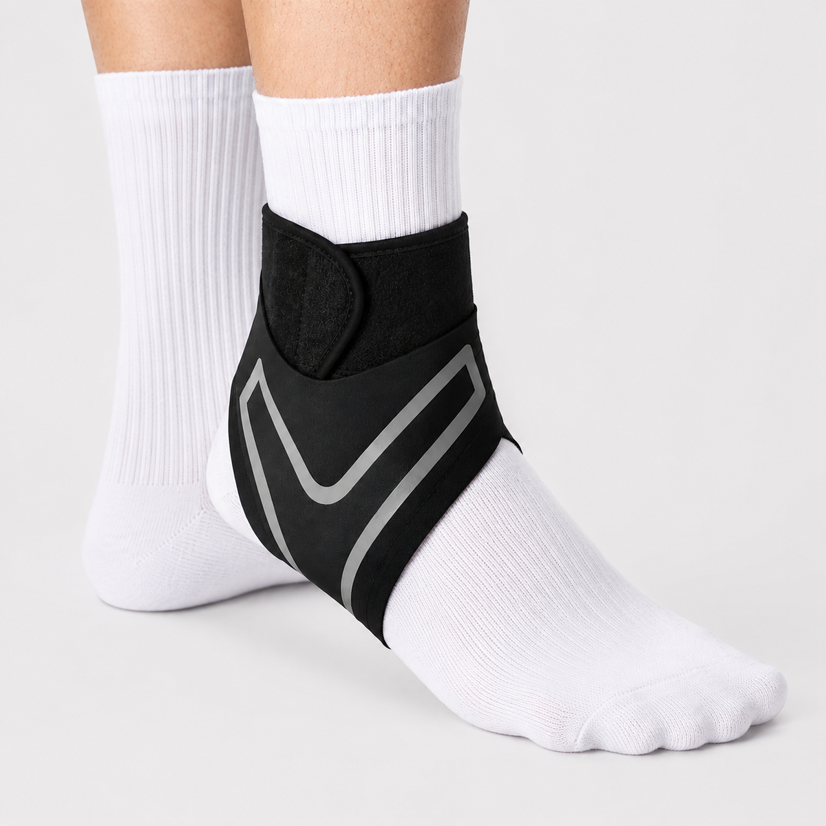 Chevillère de compression noire portée sur un pied avec chaussette blanche