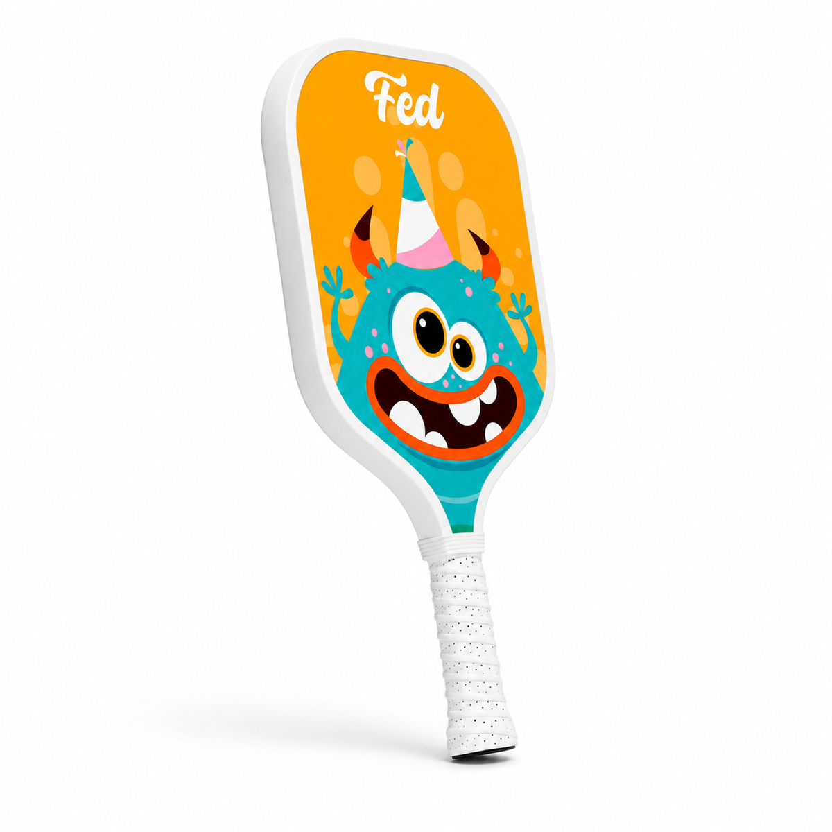 Raquette de pickleball enfant orange avec monstre Fed, vue en angle montrant le manche blanc